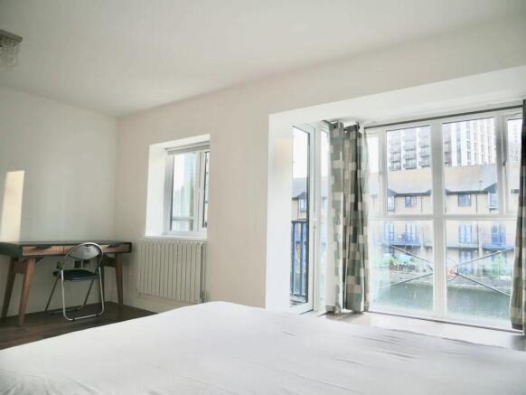 Bright and spacious master bedroom featuring la...