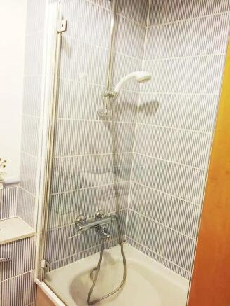 Bright and clean bathroom suite featuring a bat...