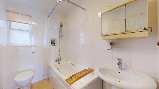 Bright and clean bathroom suite featuring a ful...