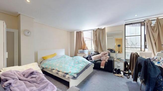 Bright double bedroom featuring a comfortable b...