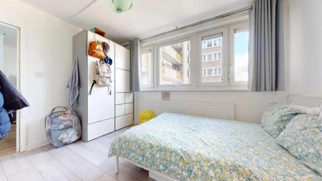 A bright and tidy double bedroom featuring a la...