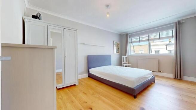 A bright and minimalist double bedroom featurin...