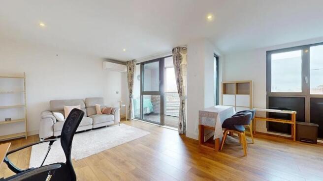 Bright and spacious living room featuring large...