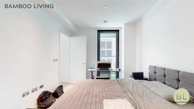 Bright and modern master bedroom featuring a co...