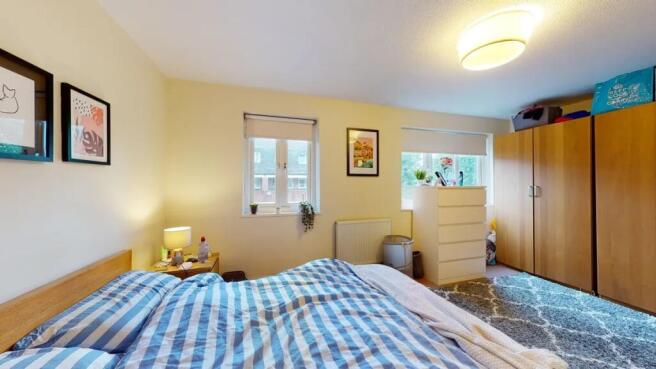 Bright master bedroom featuring a comfortable d...
