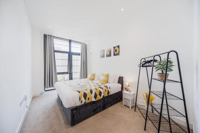 Bright and modern master bedroom featuring a la...