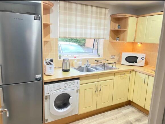 A bright and tidy kitchenette equipped with mod...