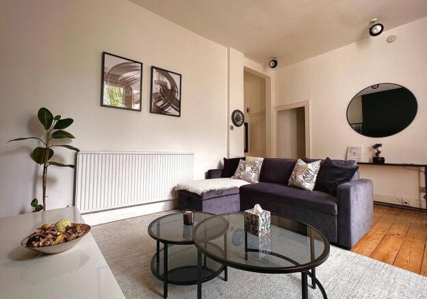 A cozy and stylish living room featuring a plus...