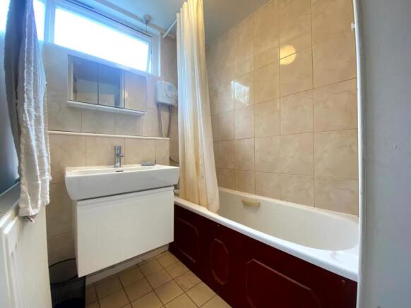 A well-lit bathroom featuring a clean white sin...