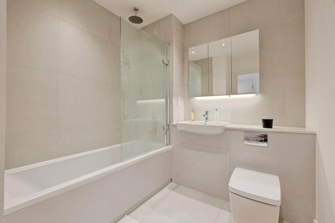 Modern bathroom with a sleek white bathtub, a s...