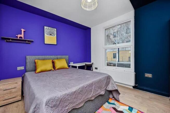 A bright and modern bedroom featuring a large b...