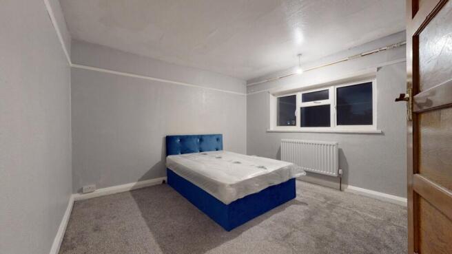 A spacious and well-lit master bedroom featurin...