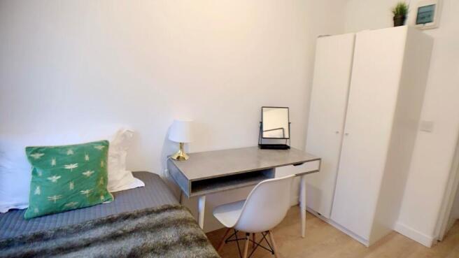 A cozy bedroom featuring a bed with decorative ...