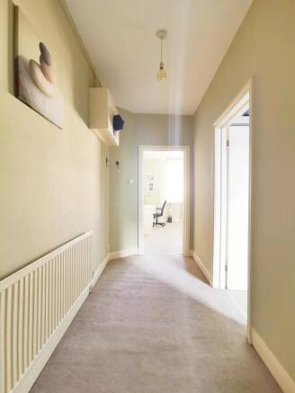 Bright and clean hallway with neutral tones and...
