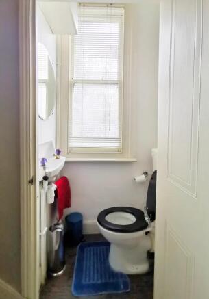 Bright and tidy single toilet room featuring a ...