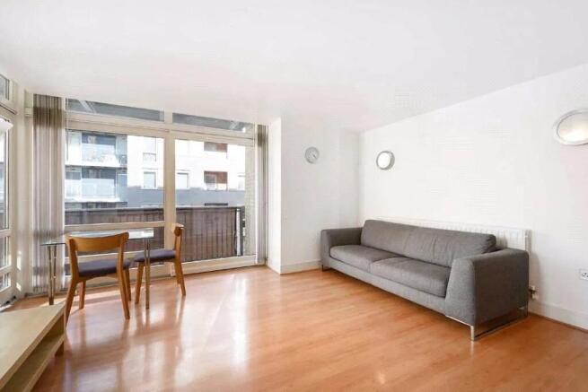 Bright and airy living room featuring large flo...