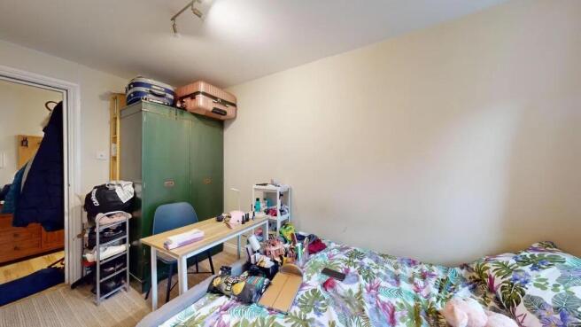 A cozy bedroom featuring a bed with vibrant bot...