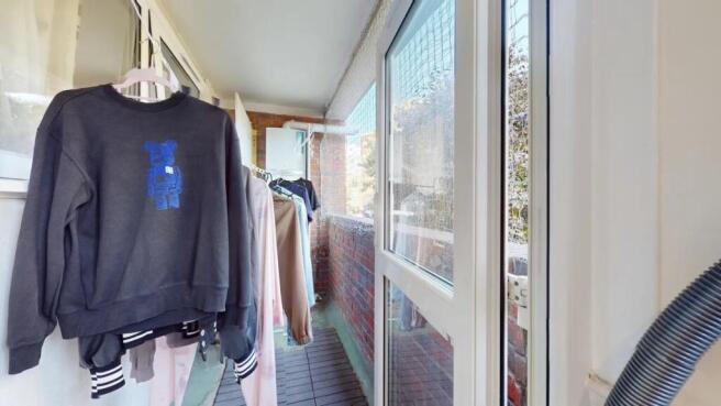 A bright enclosed balcony area with ample natur...