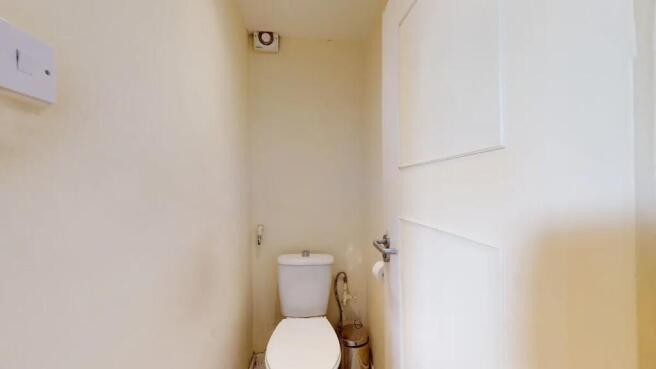 Compact and clean single toilet room with a sim...