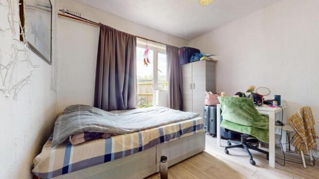 A neat and well-lit bedroom with a comfortable ...