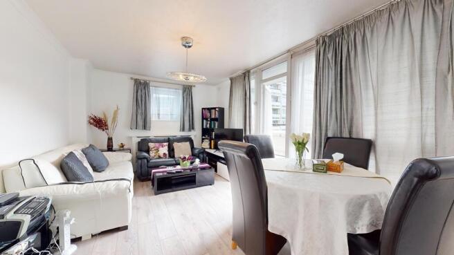 A spacious and well-lit living room featuring a...