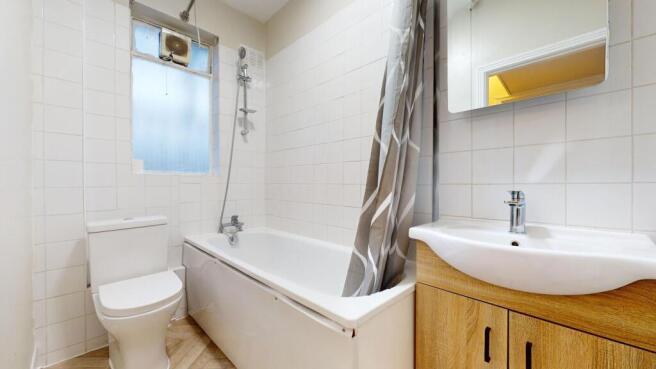 A clean and bright bathroom suite featuring a w...