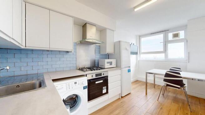 Bright modern kitchen with white cabinets, blue...