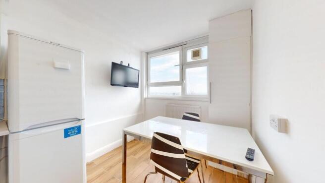 Bright compact kitchen/dining area with a large...