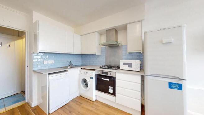 Bright modern kitchen with white cabinetry, pal...