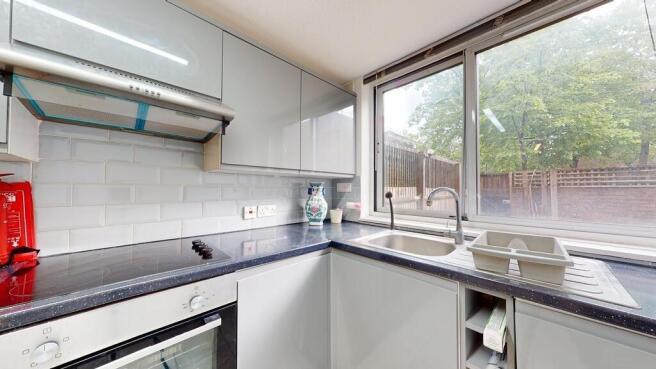 Modern U-shaped kitchen with glossy cabinets, a...