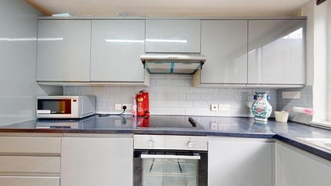 Modern fitted kitchen with glossy upper cabinet...