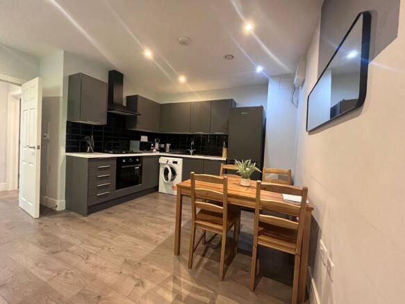 Modern open-plan kitchen with sleek dark cabine...