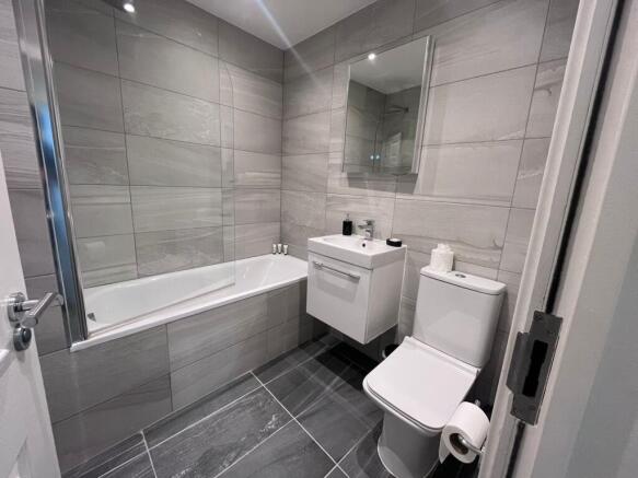 Modern tiled bathroom with a bathtub and glass ...