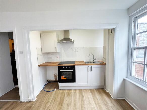 Bright, modern kitchenette with wood-effect wor...