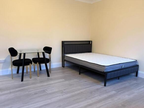 Bright, simply furnished double bedroom with a ...