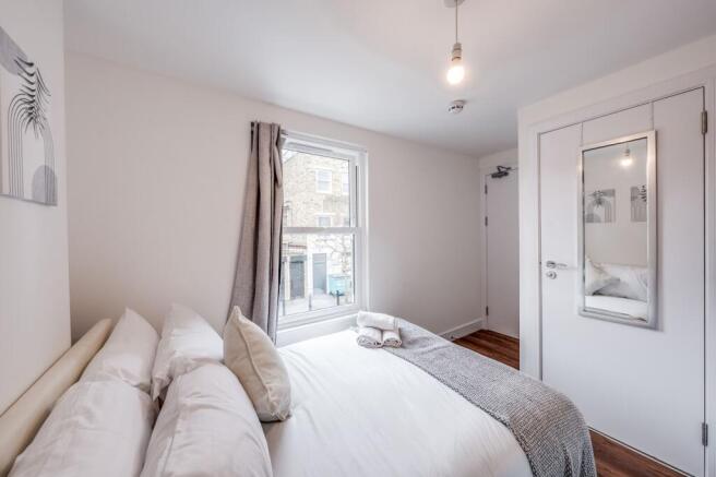 This inviting double bedroom features a cozy at...