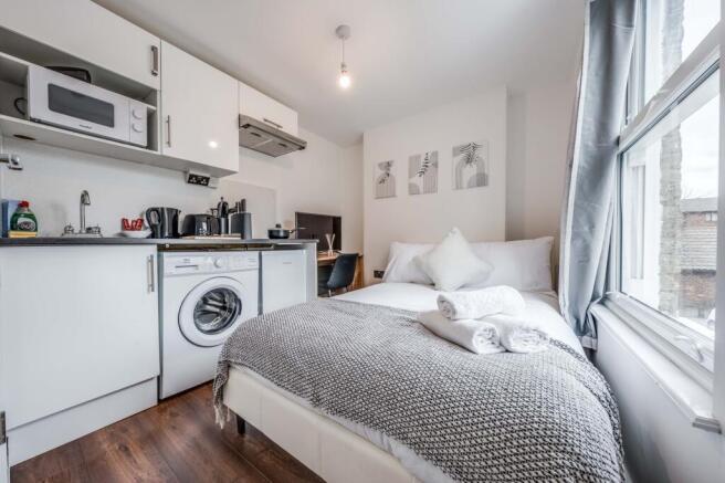 This cozy double bedroom features a comfortable...