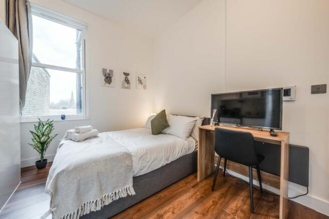 This stylish double bedroom features a cozy lay...