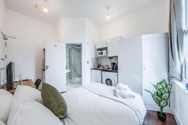 This inviting double bedroom features a cozy at...