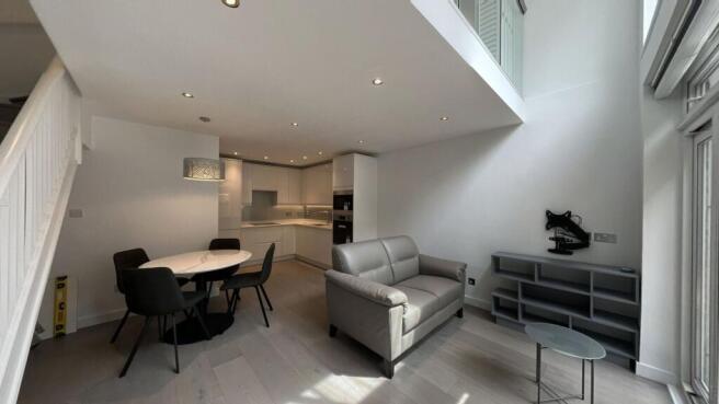 Modern and bright living room featuring an open...