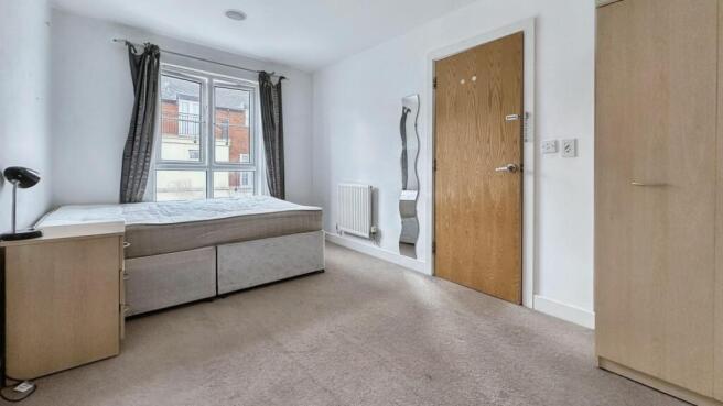 A clean and well-lit double bedroom featuring a...