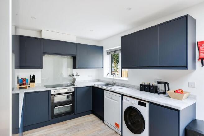 A modern and spacious kitchen with sleek cabine...