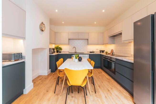 A modern and bright kitchen featuring ample spa...