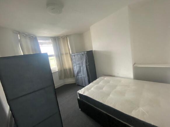 A spacious and well-lit double bedroom, perfect...