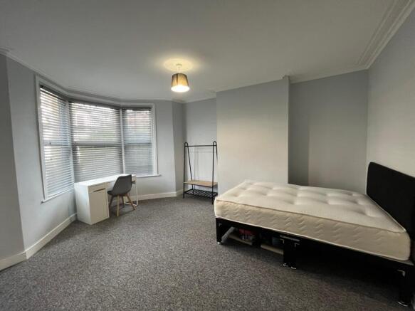 A spacious and bright double bedroom featuring ...