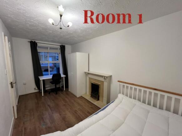 A spacious and well-lit double bedroom featurin...