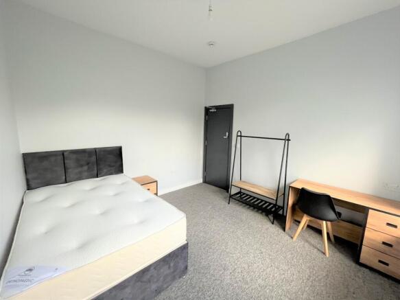 A spacious and well-lit double bedroom, perfect...