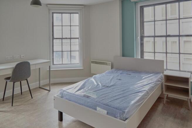 A spacious and bright double bedroom featuring ...