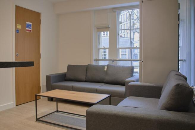 A spacious and modern living room featuring com...