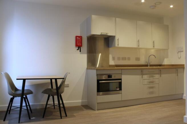 A modern and tidy kitchenette with ample storag...